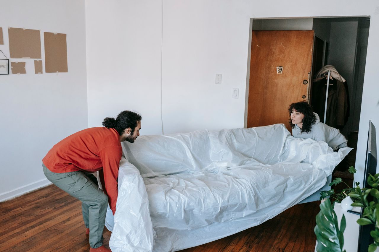 services-03 A couple carrying a couch together as they move into a new apartment.